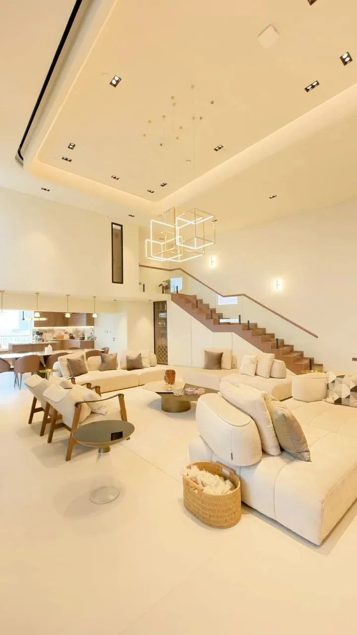 Sadaf 8, a turnkey villa by Oryx Design: a double-height living room with a floating staircase